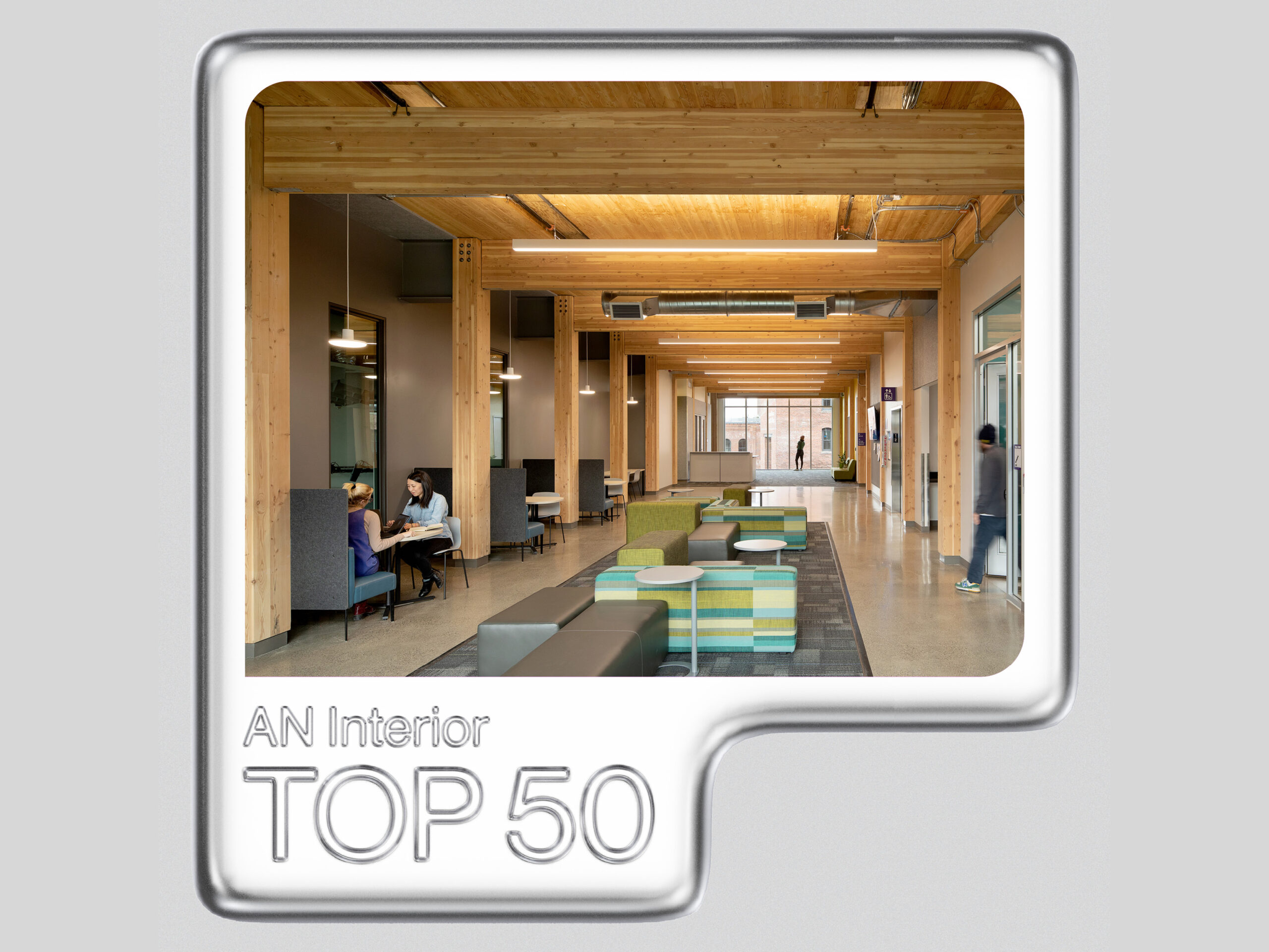 Photograph of interior hallway of mass timber building surrounded by grey graphic frame with caption "AN Interior Top 50"