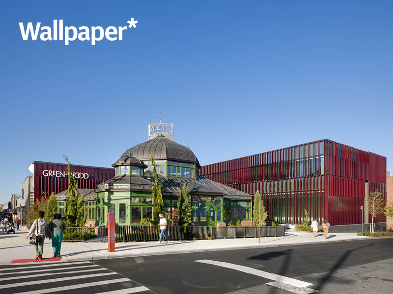 People walk in front of a historic greenhouse and new burgundy, terra cotta- clad visitor's center Image Credit: Rafael Gamo