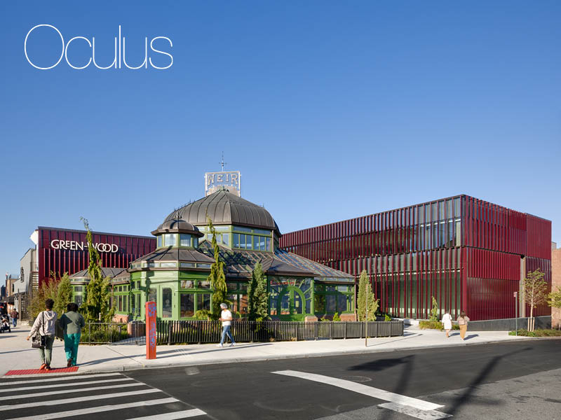 People walk in front of a historic greenhouse and new burgundy, terra cotta- clad visitor's center Image Credit: Rafael Gamo